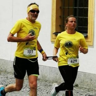 Verena Bentele läuft gemeinsam mit ihrem Kumpel Jürgen beim Halbmarathon in Kempten 2023 - über ein Seil sind sie miteinander verbunden_Copyright Lions Club Kempten-Buchenberg